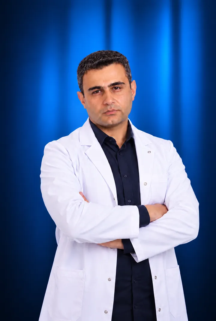 Dr. Hayk Gasparyan in a white coat, arms crossed, blue backdrop