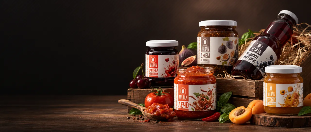 Marran jars of jam, lecho and compote with fruit on a wooden table